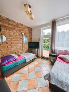 a bedroom with two beds and a brick wall at Dom na Fali Darlowko in Darlowko