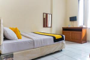 a bedroom with a bed with a dresser and a mirror at Astria Graha in Bandung