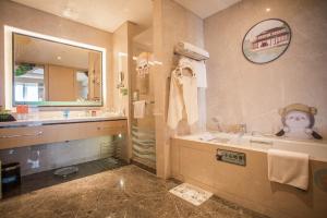 La salle de bains est pourvue d'une baignoire, d'un lavabo et d'une douche. dans l'établissement Holiday Inn Suzhou Huirong Plaza, an IHG Hotel, à Suzhou