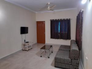 a living room with a couch and a tv at Raaj Inn studio's in Candolim