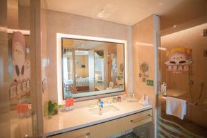 ein Bad mit einem Waschbecken und einem Spiegel in der Unterkunft Holiday Inn Suzhou Huirong Plaza, an IHG Hotel in Suzhou