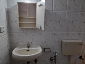 a white bathroom with a sink and a toilet at Raaj Inn studio's in Candolim +25 photos