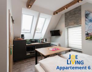 ein kleines Wohnzimmer mit einem Tisch und einer Küche in der Unterkunft Living inStein in Krems an der Donau