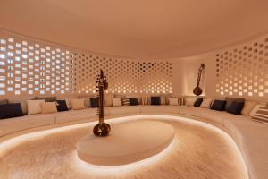 a living room with a large couch and a guitar at Six Senses Ibiza in Portinatx