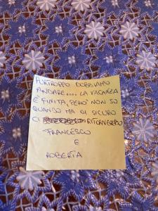 un trozo de papel con una nota encima de una tela azul en La Casa di Lulu', en Palinuro