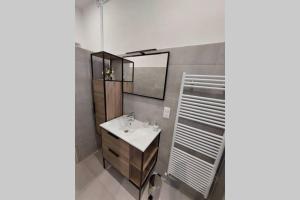 uma casa de banho com um lavatório e um espelho em Les clématites em Narbona