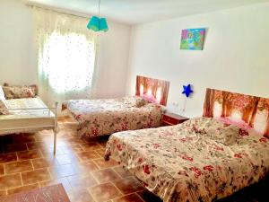 um quarto com 2 camas e uma janela em Casa Rural Hoyo de Los Pájaros em Castril