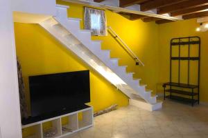 uma sala de estar com uma escada e uma televisão em Cá Greta em Chioggia