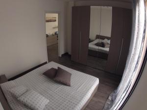 Dormitorio pequeño con cama y espejo en Il Nuovo Palazzotto, en Stresa