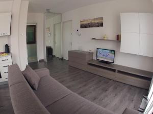 un soggiorno con divano e TV a schermo piatto di Il Nuovo Palazzotto a Stresa