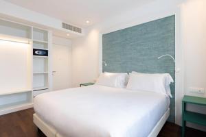
a bedroom with a white bed and white walls at Hotel Morfeo in Milan
