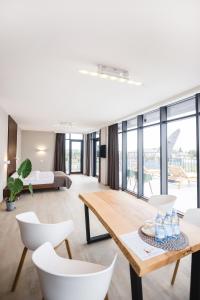 ein Wohnzimmer mit einem Tisch und weißen Stühlen in der Unterkunft Sofia Hotel in Velyka Omelyana