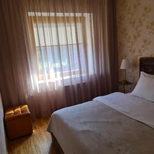 um quarto com uma cama e uma grande janela em Rietumkrasta seaside apartment em Liepāja