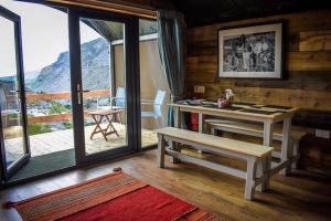 a room with a table and a bench and a balcony at Llechwedd Glamping in Blaenau-Ffestiniog