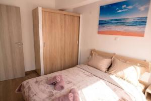 a bedroom with a bed with pink slippers on it at ARGY’S HOME in Alexandroupoli