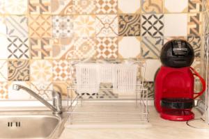 a kitchen counter with a red toaster next to a sink at ARGY’S HOME in Alexandroupoli +45 photos