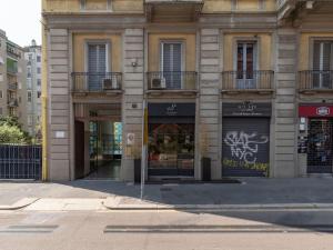 um edifício numa rua da cidade com uma loja em The Best Rent - Lovely loft with balcony near Piazza Vetra em Milão