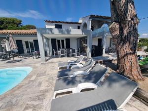 a group of lounge chairs next to a house at Villa beaupré les Issambres Roquebrune sur argens, frejus in Les Issambres
