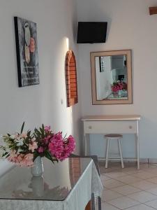 a dining room with a glass table and a mirror at Stefanos Studios in Skala