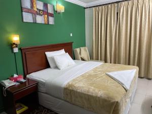 a bedroom with a bed and a green wall at Royal Prince Hotel in Dubai