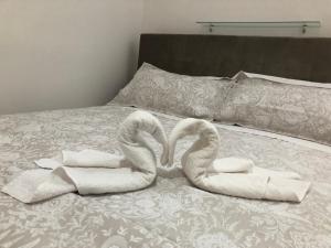 two towel swans sitting on top of a bed at Casa Morganti- in Sesto San Giovanni