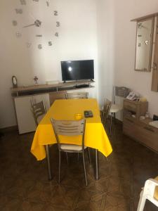 a yellow table and chairs in a room at Casa Vico Torre in Santa Croce di Magliano +1 photo