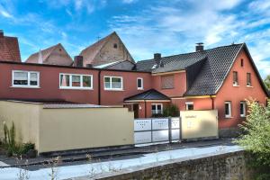 a red house with a fence in front of it at Ferienwohnung Landsknecht in Volkach