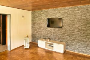 a living room with a tv on a brick wall at Ferienwohnung Landsknecht in Volkach
