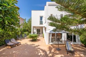 een uitzicht op een huis met stoelen en bomen bij Villa Mar - Can Bujosa in Palma de Mallorca