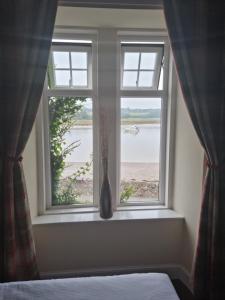 a bedroom window with a view of the water at The Anchor Hotel in Kippford