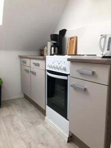 a kitchen with a white stove top oven next to a counter at Ferienwohnung Max in Rethwisch