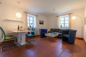 ein Wohnzimmer mit einem Sofa, einem Tisch und Stühlen in der Unterkunft Feriendorf Rugana - Komfort Appartement mit 1 Schlafzimmern und Terrasse C39 in Dranske