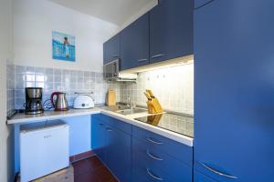 una cocina con armarios azules y fregadero en Feriendorf Rugana - Budget Appartement mit 1 Schlafzimmer C40, en Dranske