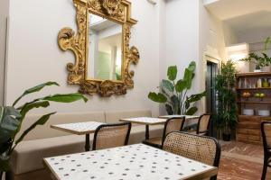 a mirror on a wall with tables and chairs at Hotel Infanta Isabel by Recordis Hotels in Segovia