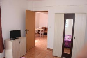 a living room with a television and a room with a table at Vila Bucura 19 in Venus
