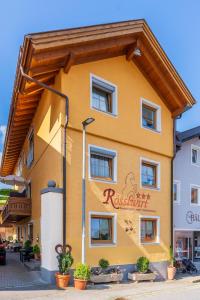 un edificio amarillo con un cartel. en Wander und Aktiv Hotel Rösslwirt, en Lam