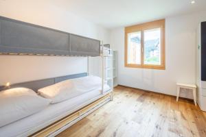 - une chambre avec des lits superposés et une fenêtre dans l'établissement LAAX Homes - Taviarna Laax 1,9, à Laax