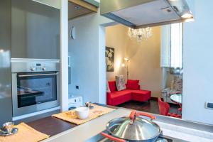 uma cozinha e sala de estar com um sofá vermelho em Mamo Florence - Indipendenza Apartment em Florença