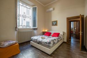 um quarto com uma cama com duas almofadas vermelhas em Mamo Florence - Indipendenza Apartment em Florença