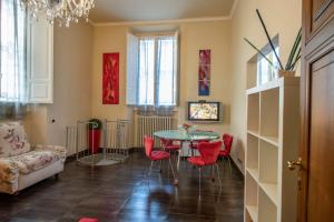 uma sala de estar com uma mesa e cadeiras vermelhas em Mamo Florence - Indipendenza Apartment em Florença