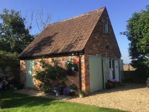 a small brick building with a garage at The Annex @ 3 East Town Cottages in West Ashton