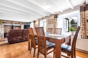 a dining room with a table and chairs and a couch at Tresowes Green Cottage in Helston