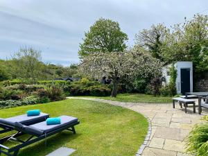 a garden with picnic tables on the grass at Tresowes Green Cottage in Helston