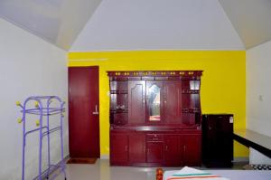 Habitación con armario rojo y pared amarilla. en Keratheeram Beach Resort, en Varkala