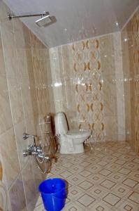 a bathroom with a toilet and a bucket in it at Keratheeram Beach Resort in Varkala