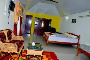 a bedroom with a bed and a couch and a chair at Keratheeram Beach Resort in Varkala