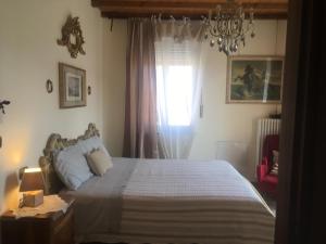 a bedroom with a bed and a window with a chandelier at B&B CM Ranch in Cuneo