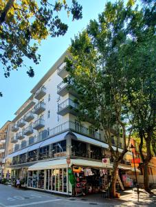 ベッラーリア・イジェア・マリーナにあるLively Hotelの店舗が目の前にあるアパートメントビル