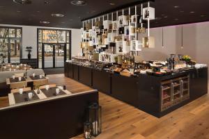 a restaurant with a counter with sinks and a buffet at INNSiDE by Meliá Frankfurt Ostend in Frankfurt/Main