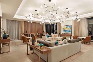 d'un salon avec un grand canapé et un lustre. dans l'établissement Wyndham Dubai Deira, à Dubaï